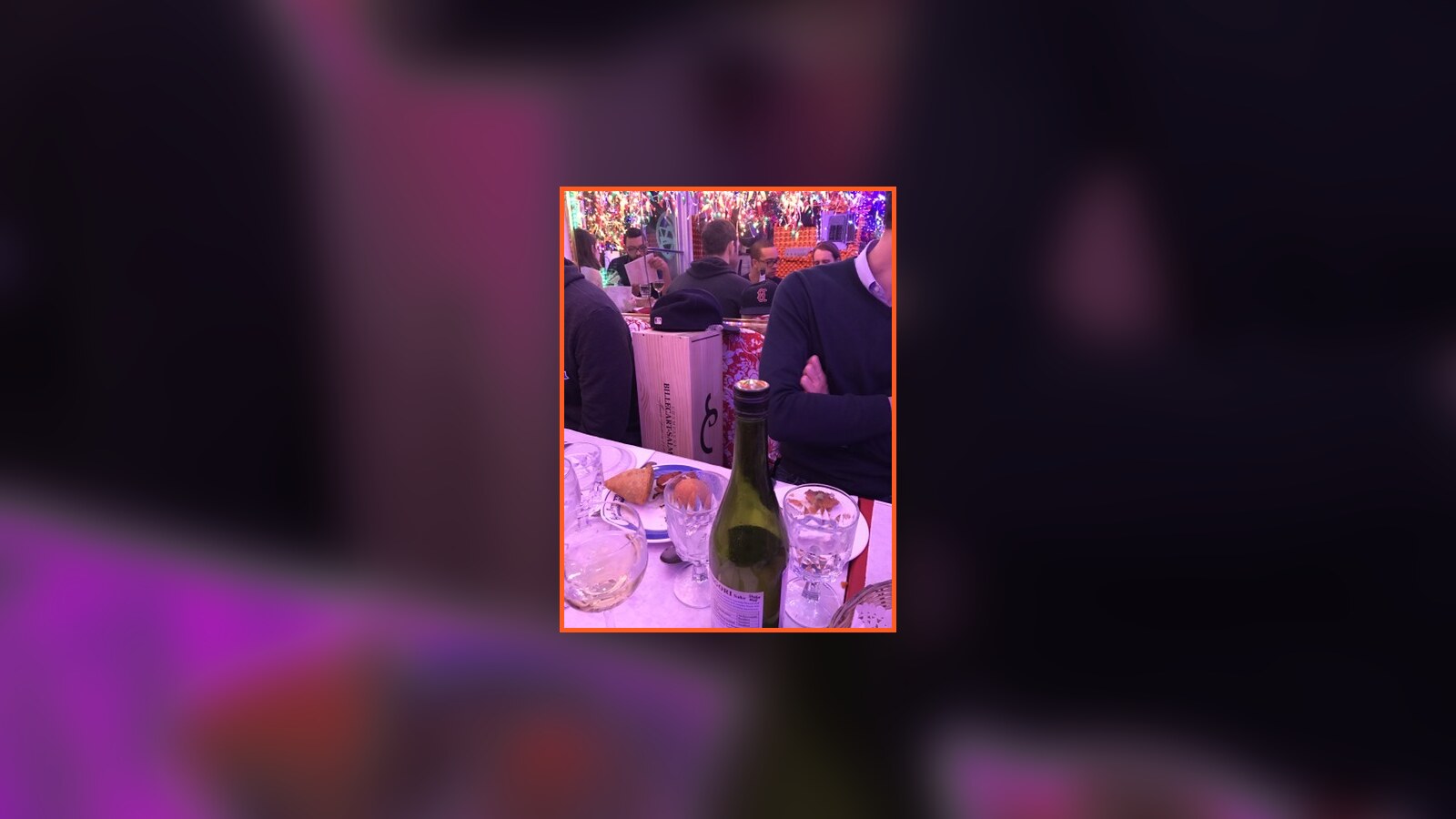Friends gathered around the giant bottle of champagne