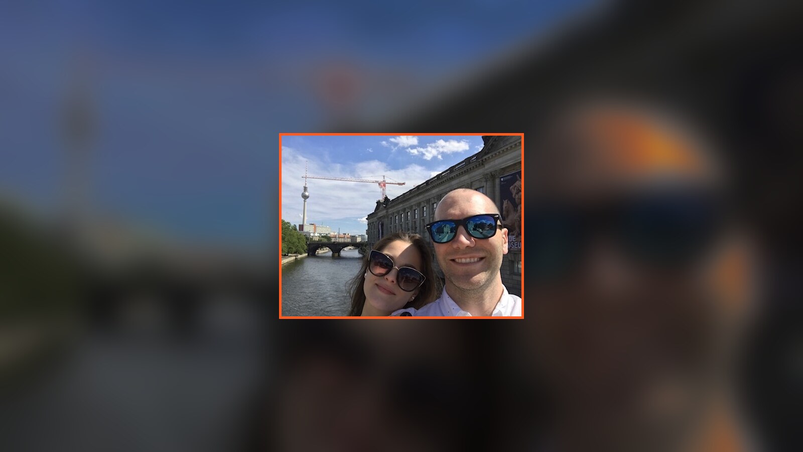 Amanda and Chris taking a selfie beside the Spree with the Berlin TV Tower behind them