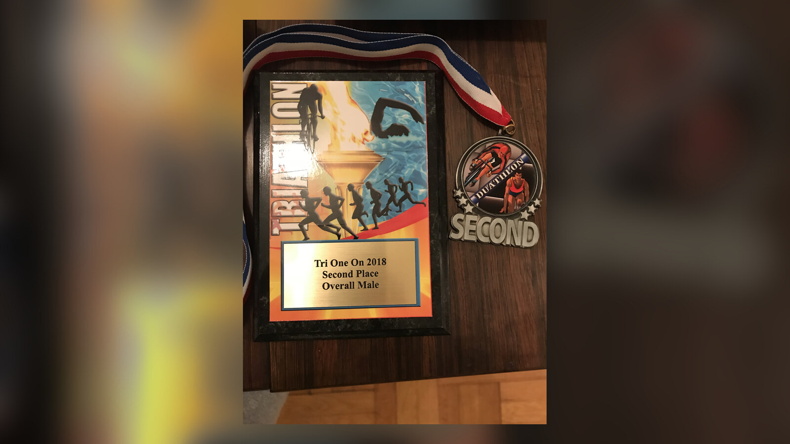 Tri One On second-place plaque and duathlon medal on a wooden table