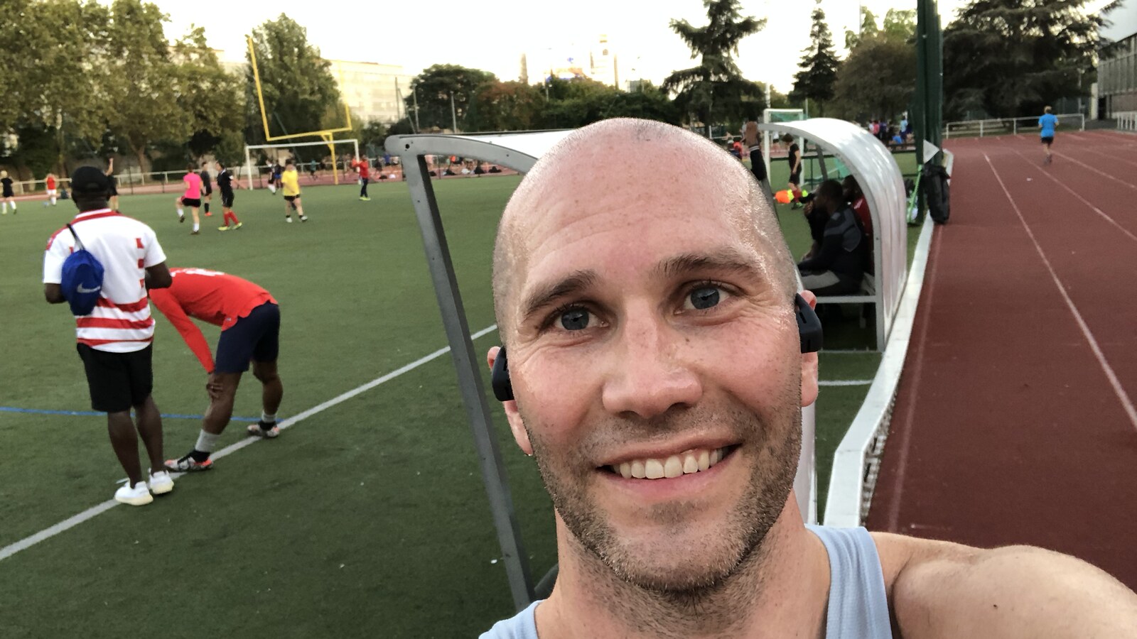 Chris Fischer smiling beside the 400-meter track where he ran mile repeats in Paris