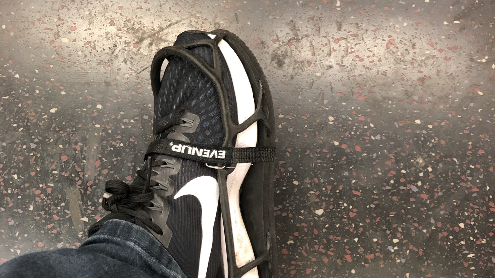 Chris's sneaker strapped into an Evenup shoe balancer while his injured foot was in a walking boot