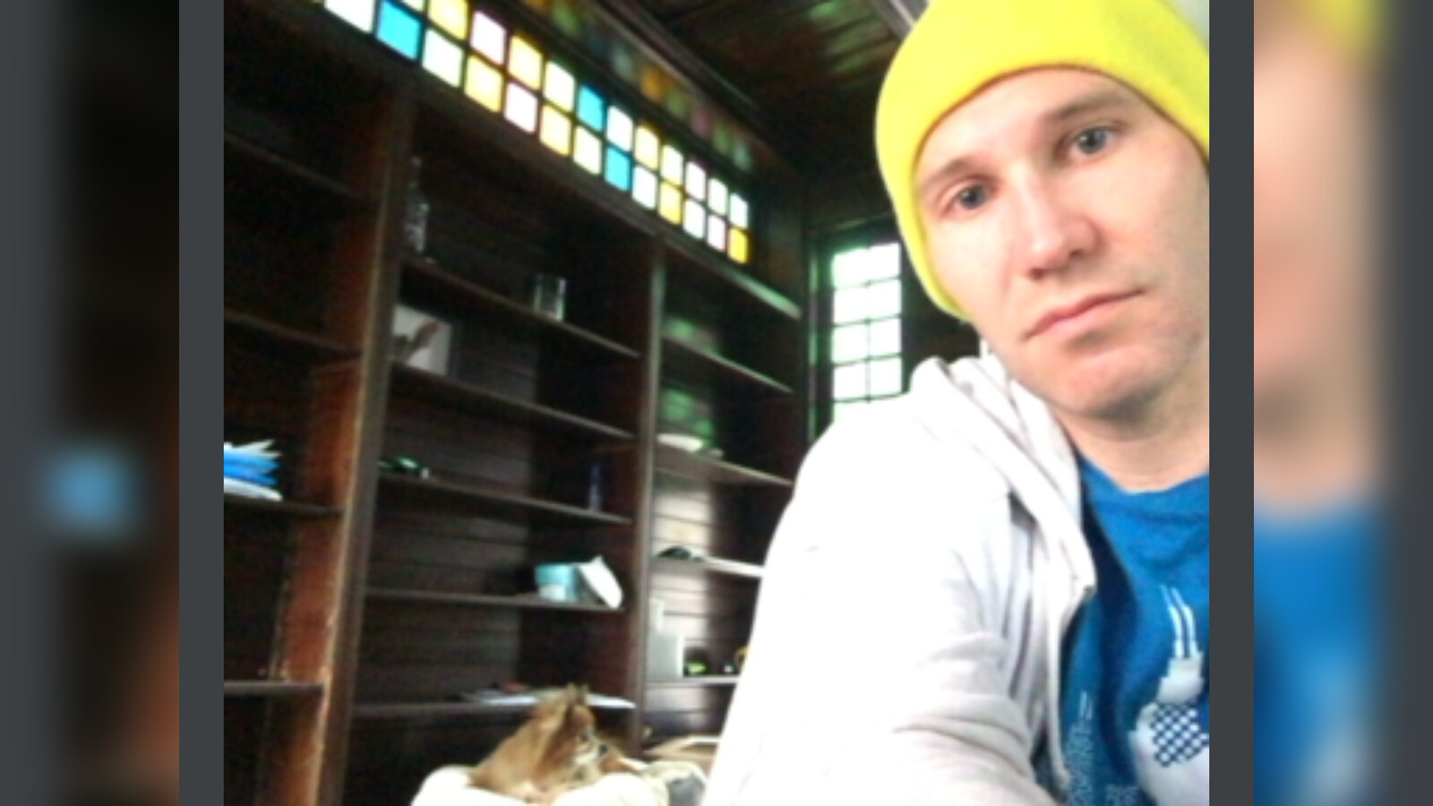 Chris in a yellow hat sitting with Eva inside the dark wood library of the Poughkeepsie house