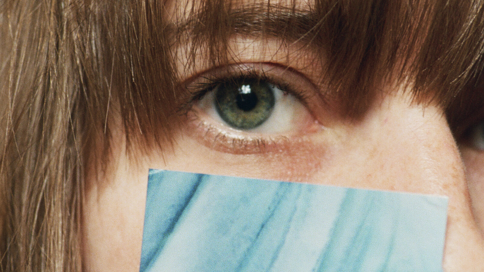 Apply 2020 campaign photograph with a blue Vote sticker held across a woman's face