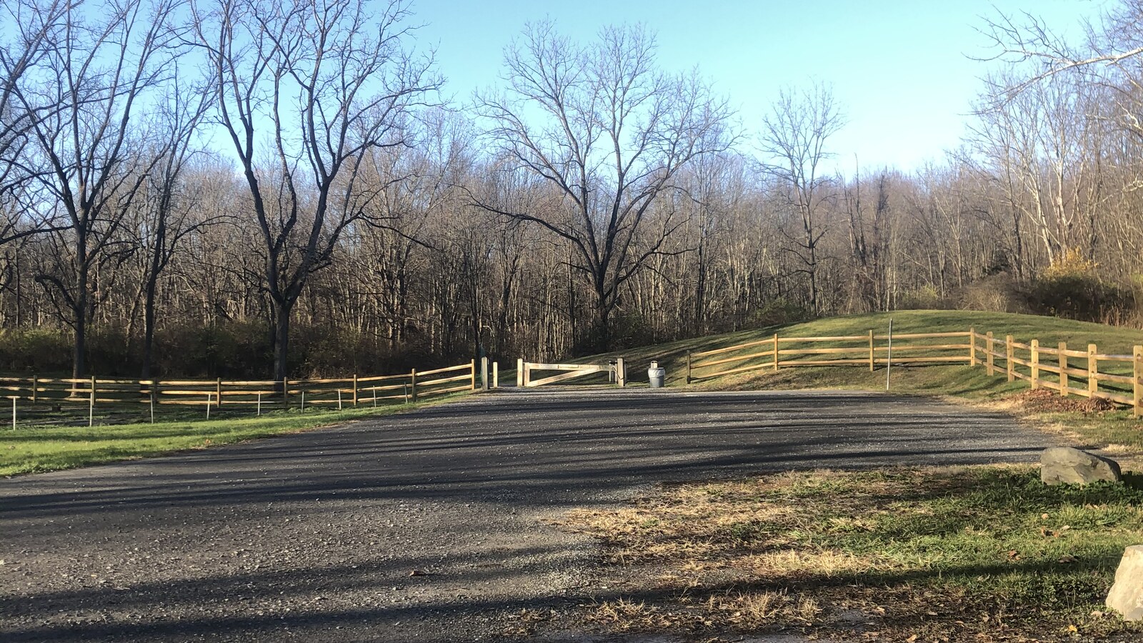 A gravel path beside split-rail fencing and bare trees near Poughkeepsie
