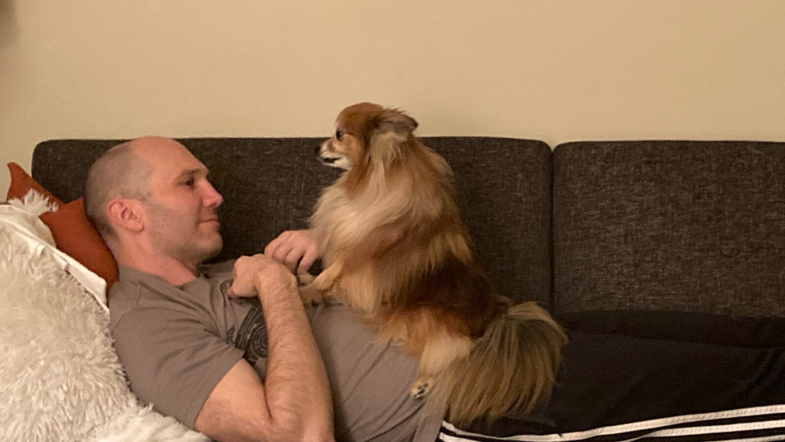 Chris Fischer relaxing on a couch with Eva at home in Cold Spring