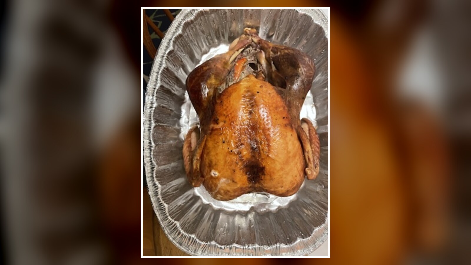 A roasted Thanksgiving turkey resting in a large foil pan