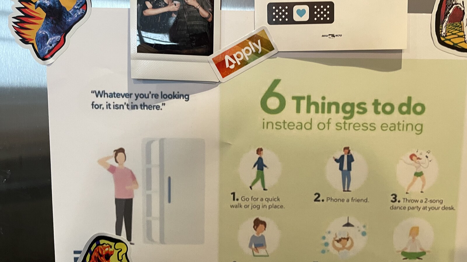 An Apply logo sticker among art and notes on a refrigerator