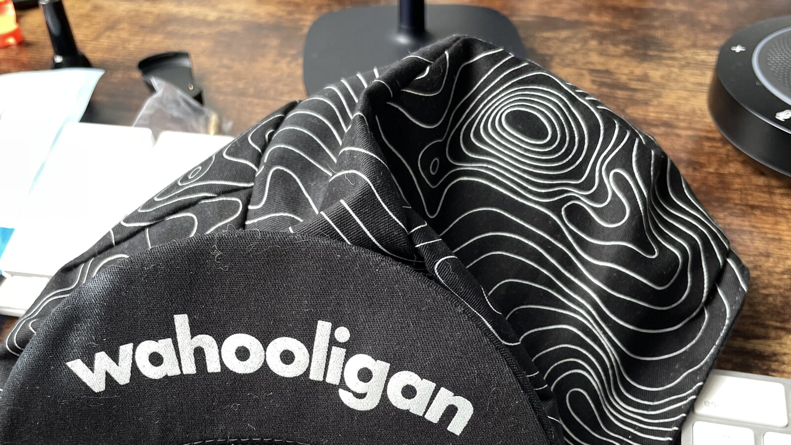 A black Wahooligan cycling cap on Chris Fischer's desk beside an Apply sticker