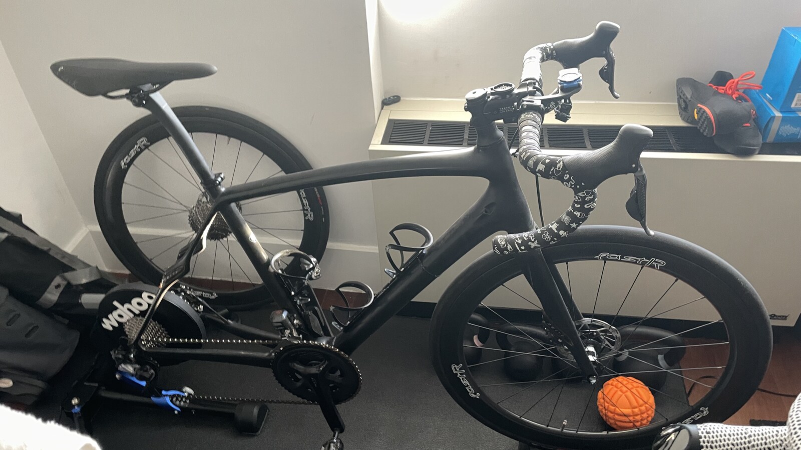 A black road bike mounted on a Wahoo KICKR in Chris's New York apartment