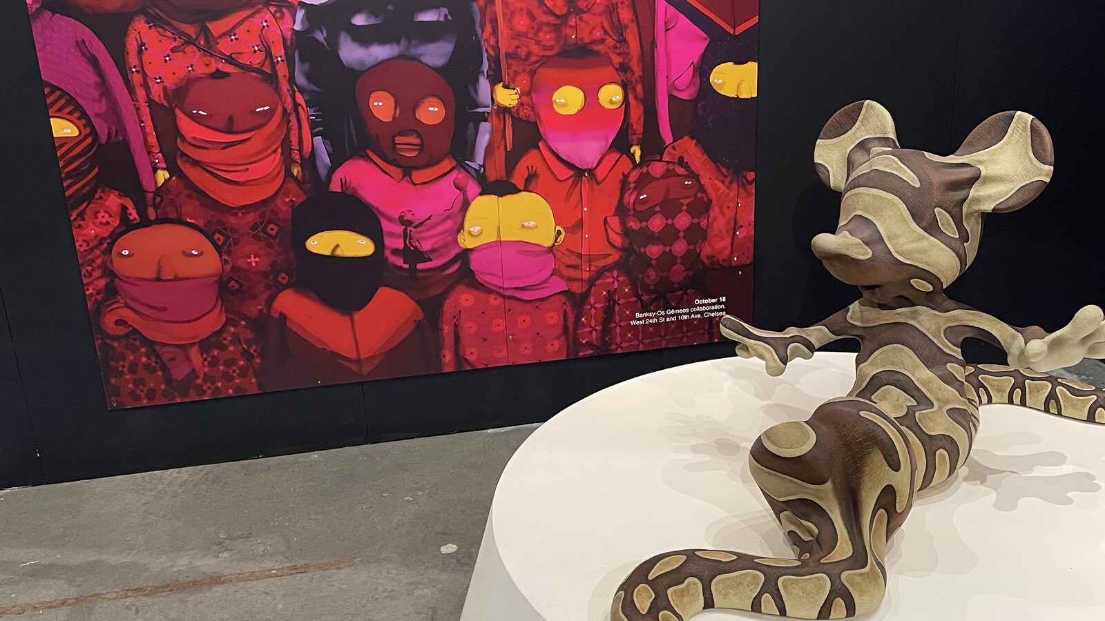 A colorful masked-figure mural and a mouse-shaped sculpture at Banksy in New York