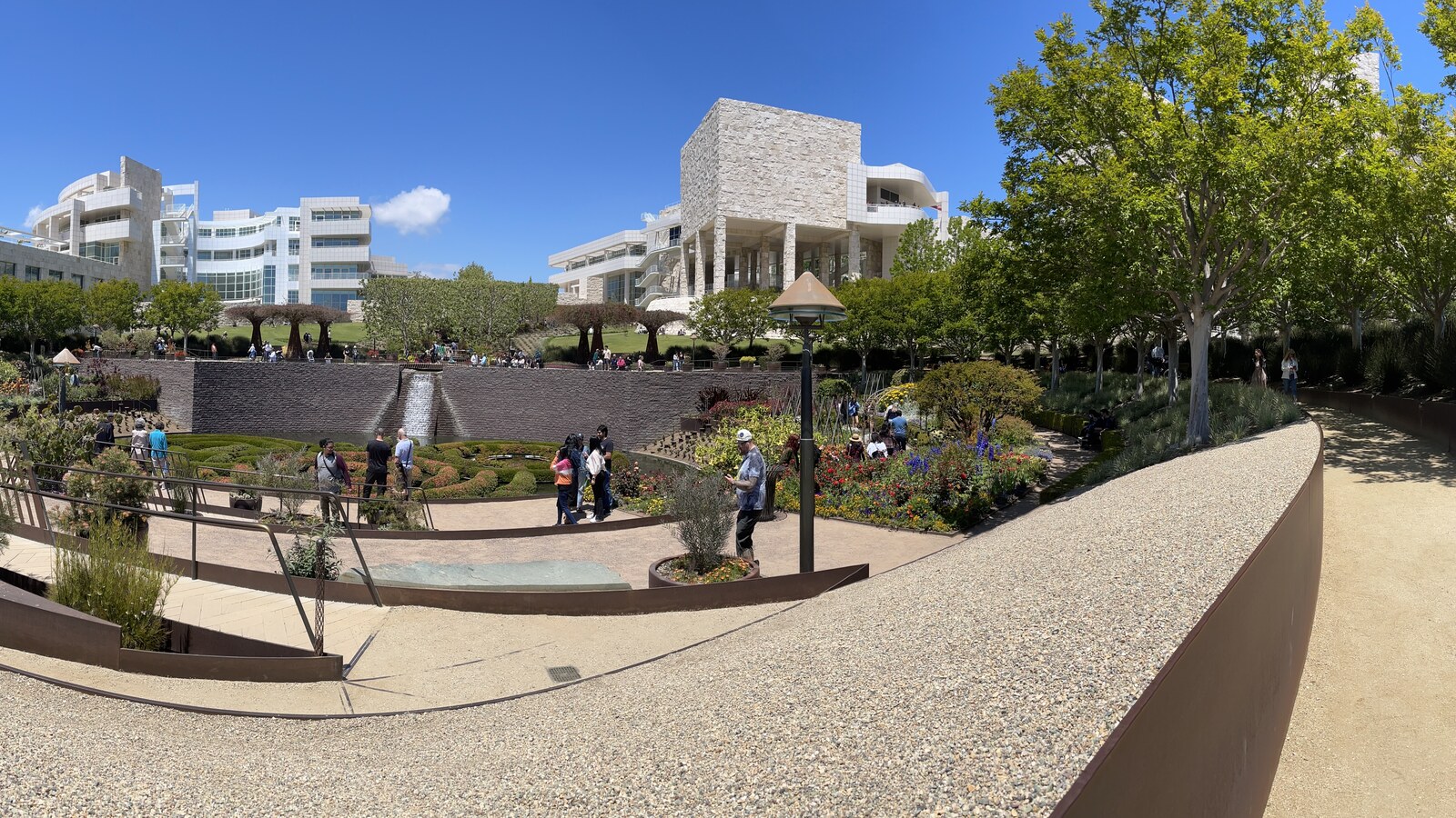 The Getty Center's Central Garden beneath white stone buildings and a clear blue sky