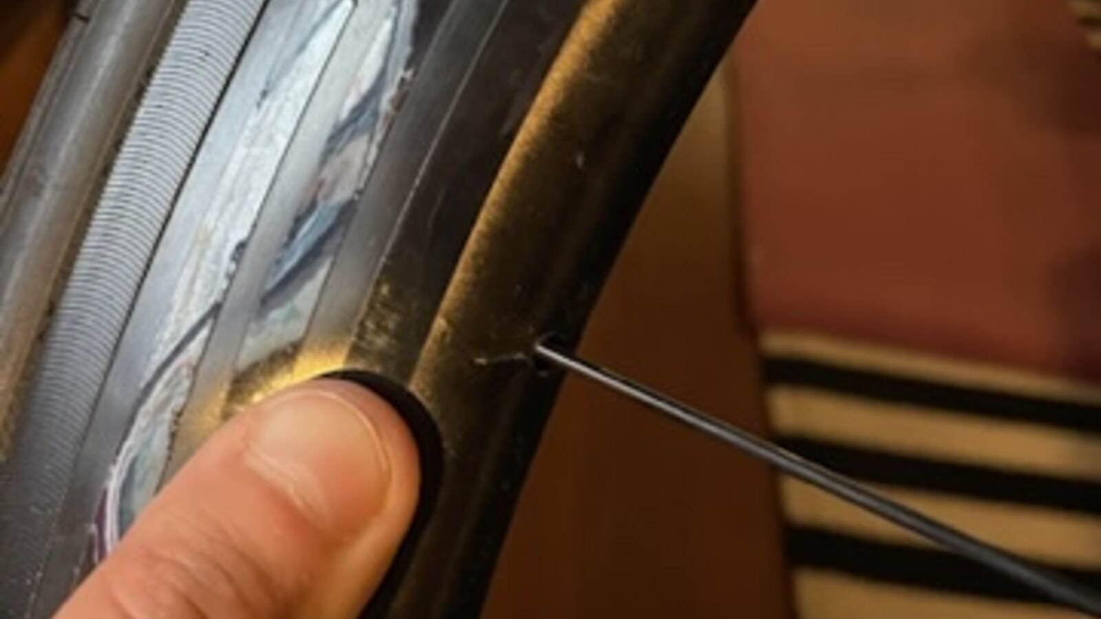 A close view of a split bicycle tire held against the wheel rim