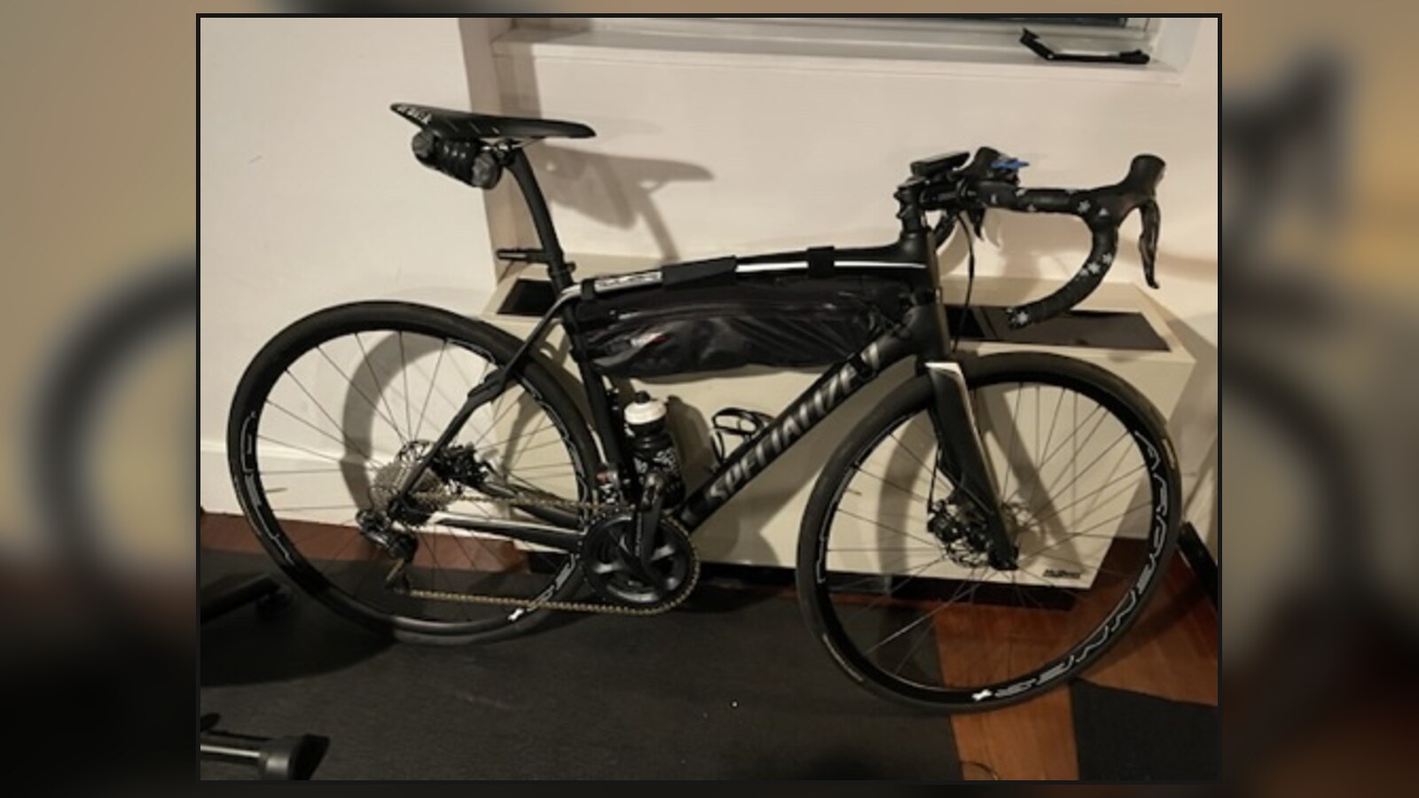 Chris's black Specialized Roubaix bicycle set up inside an apartment