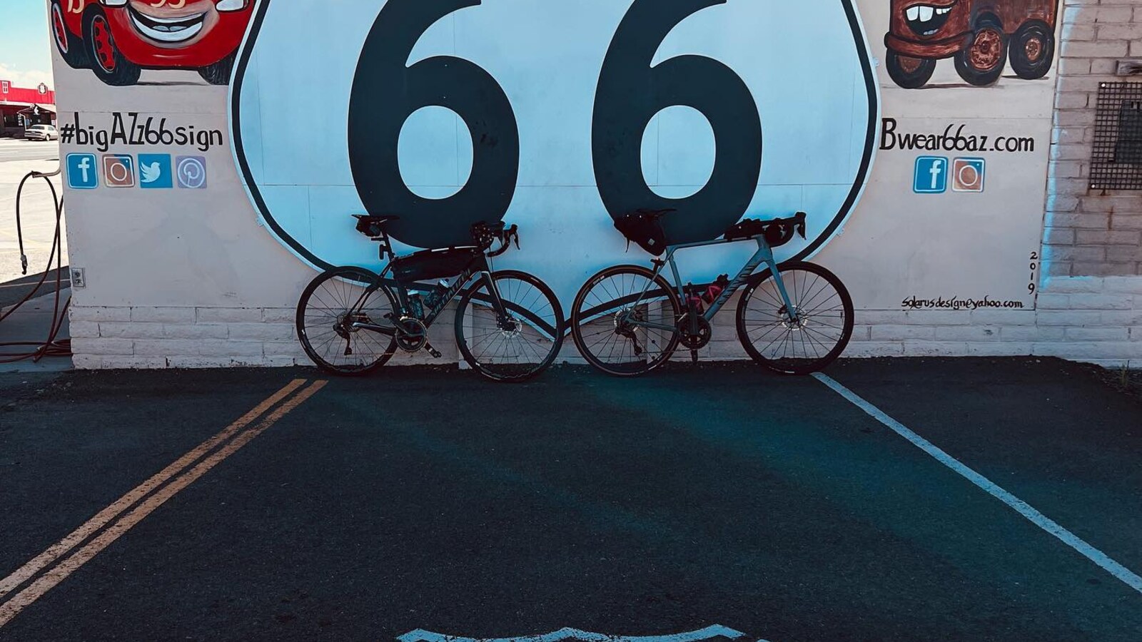Two road bikes resting beneath a huge Route 66 mural in Arizona