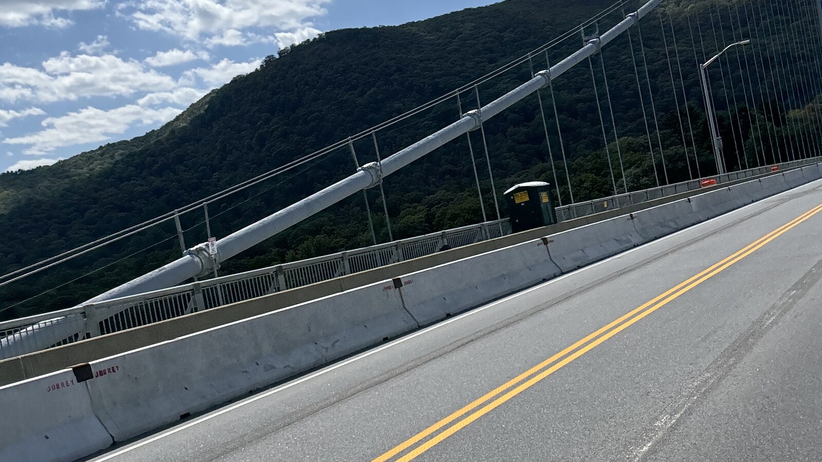Bear Mountain Bridge and the forested mountain viewed from the road during a bike ride