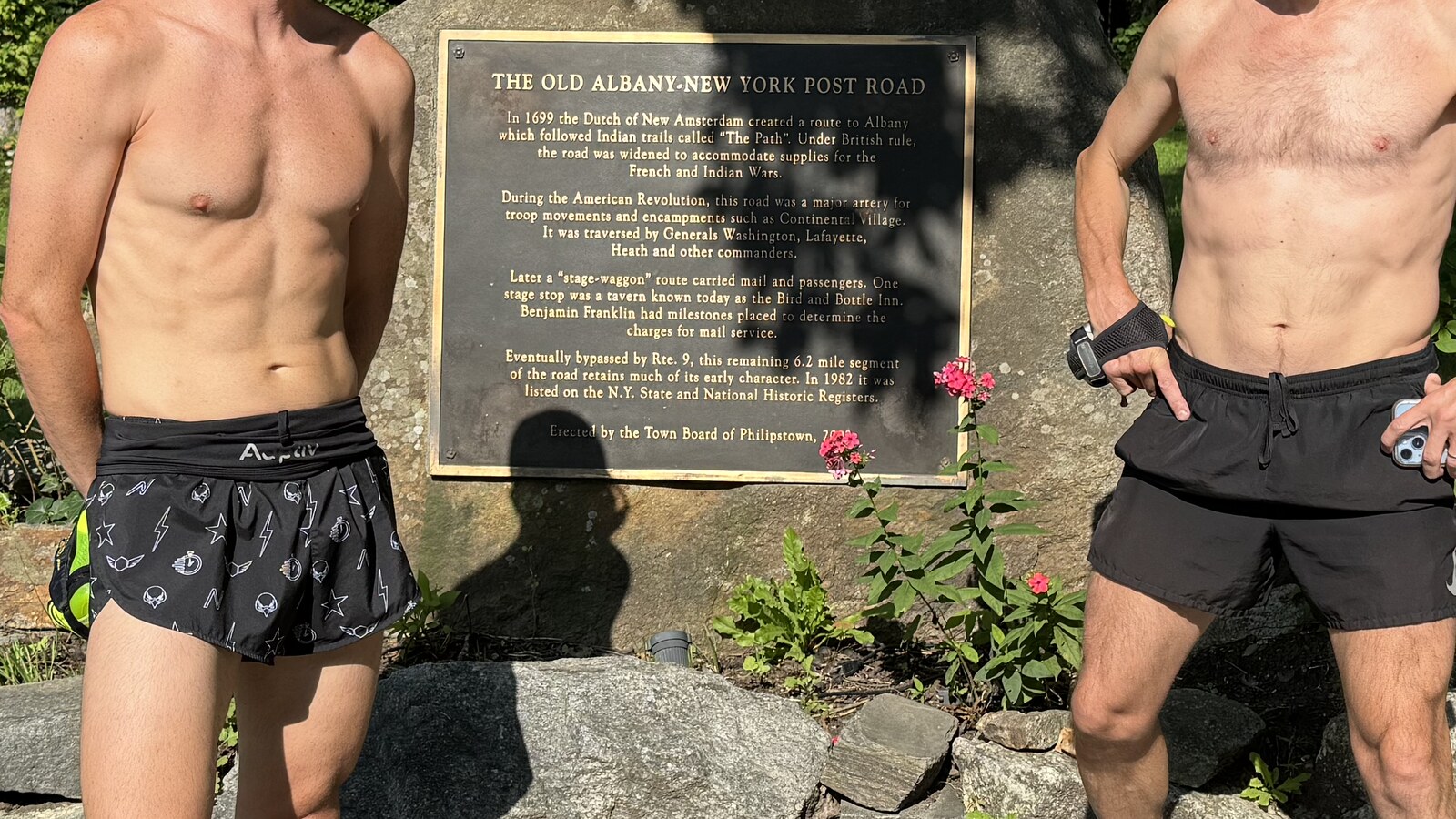 The Old Albany-New York Post Road marker between two runners in the Hudson Valley