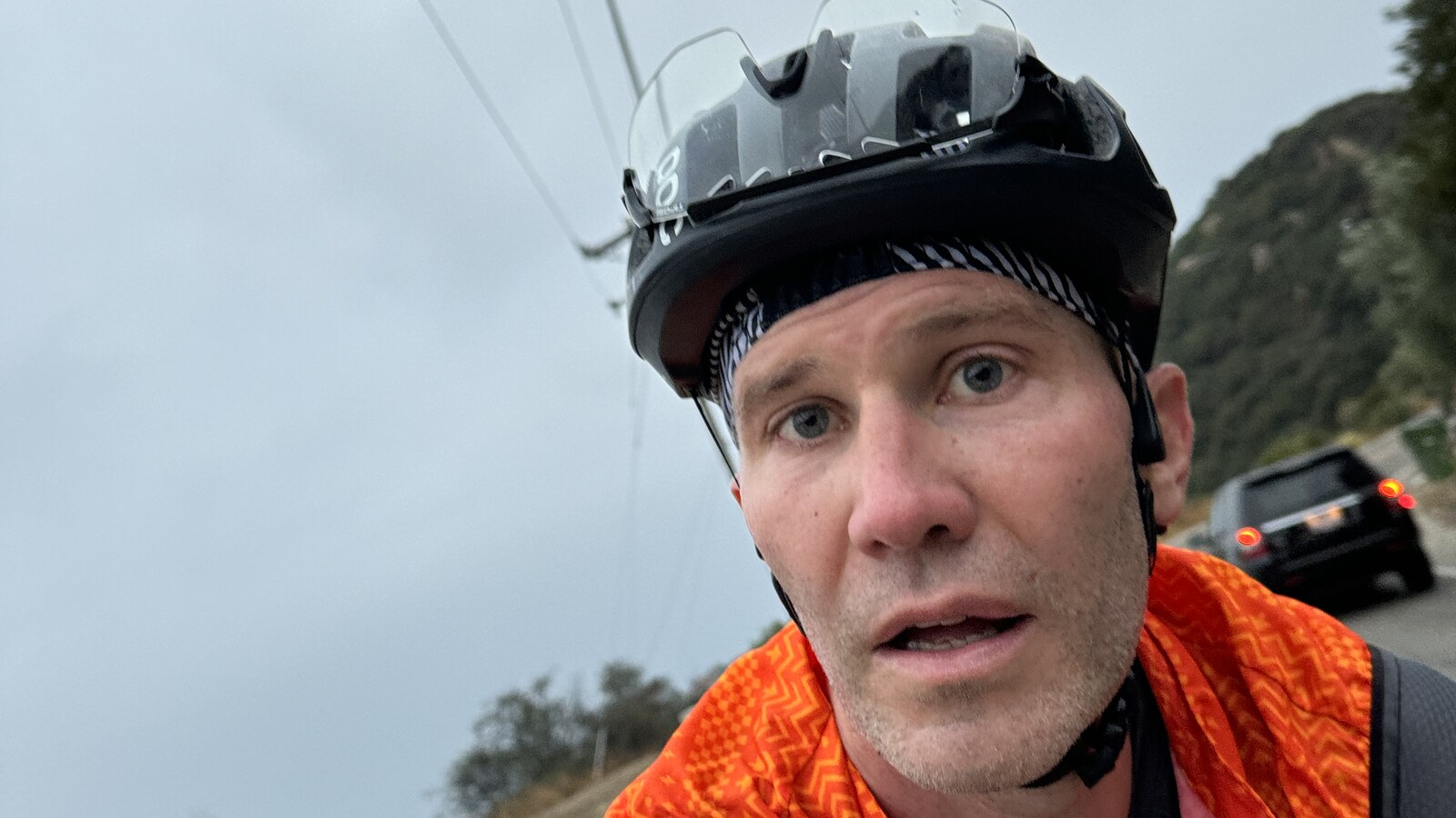 Chris Fischer riding a bicycle on a cloudy road near Los Angeles